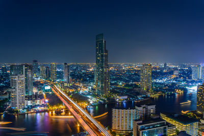 High angle view of illuminated cityscape against sky at dusk