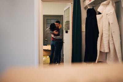 Couple embracing seen from doorway in new apartment