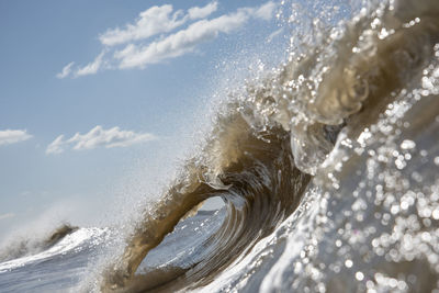 Waves splashing in sea against sky