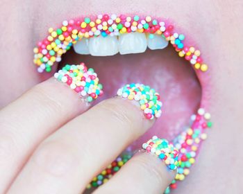 Close-up of person hand holding multi colored candies