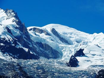 Scenic view of snow covered mountains against clear sky