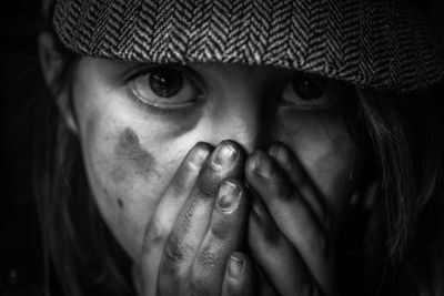 Close-up portrait of girl with hands covering mouth