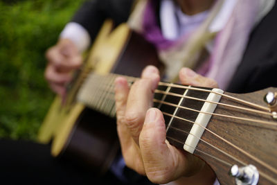 Midsection of person playing guitar