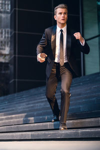 Full length of businessman moving down on steps