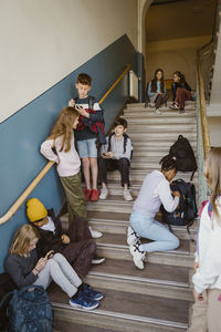 Male and female students on steps of school building