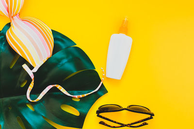 Close-up of sunglasses on table against yellow background