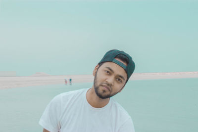 Portrait of young man standing at beach