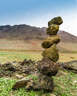 Stack of rocks on land against sky