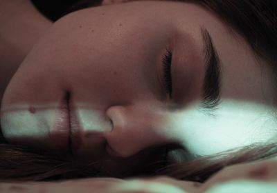 Close-up of young woman sleeping on bed at home