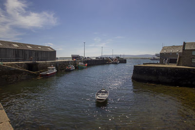 Boats moored in sea against buildings in city