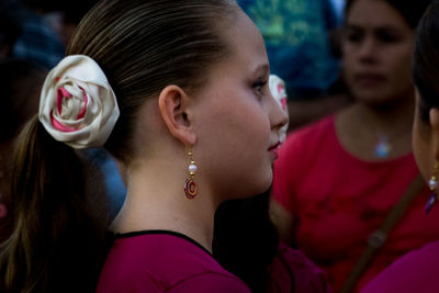 Side view of young woman wearing earring and hair accessory outdoors