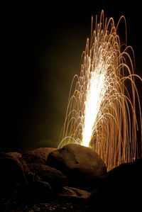 Firework display by rocks at night