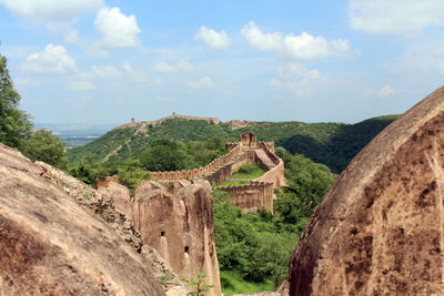 Old ruins on landscape against cloudy sky