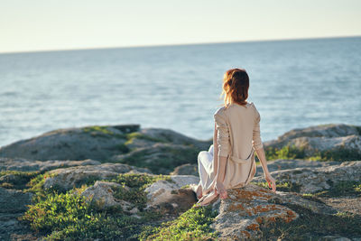 Rear view of woman looking at sea against sky