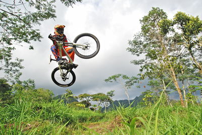 Low angle view of person riding bicycle against sky