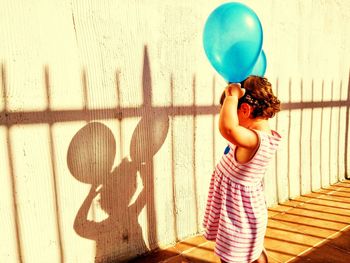 Rear view of girl holding balloons