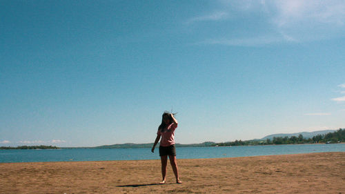 Woman standing against sea at beach