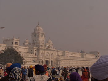 People at temple against sky in city