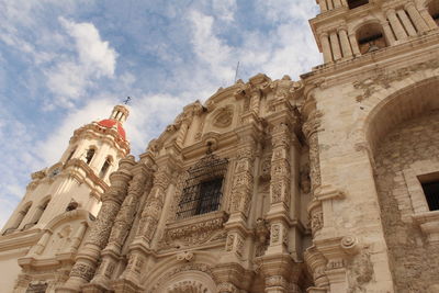 Low angle view of statue of historic building against sky