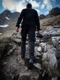 Rear view of man standing on snow covered mountain