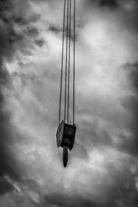 Low angle view of swing hanging against sky