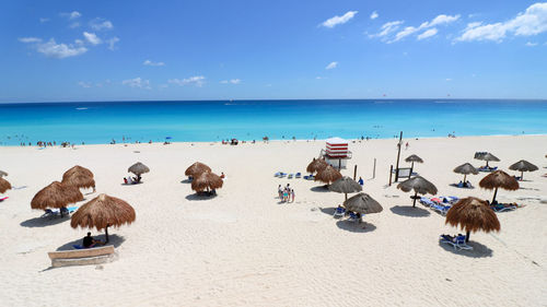 Panoramic view of people on beach against sky