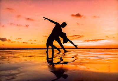 Silhouette man at beach against sky during sunset