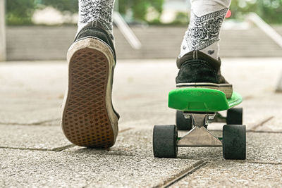 Close-up of guy legs in shorts on an outdoor penny skateboard person