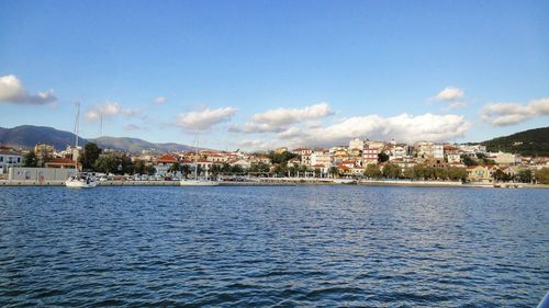 Scenic view of sea by buildings against sky