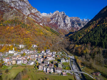 Scenic view of townscape by mountain against sky