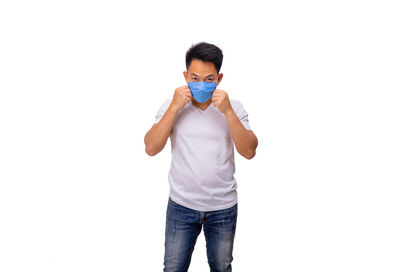 Full length portrait of young man standing against white background