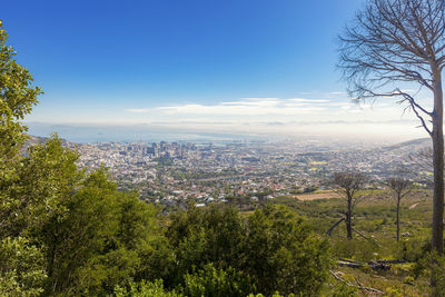 High angle view of buildings in city against blue sky