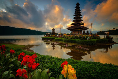 Panoramic view of temple by building against sky during sunrise