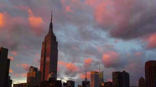 Low angle view of skyscrapers against cloudy sky