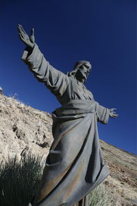 Low angle view of jesus christ statue against mountain