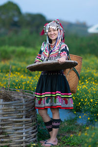 Woman holding umbrella standing on field