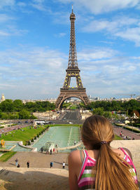Rear view of woman looking at eiffel tower against sky