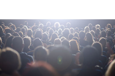 Rear view of people enjoying at concert against sky