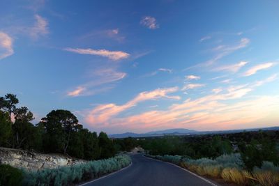 Road amidst trees against sky