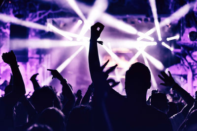 Concert crowd with raised arms applauding at a music festival
