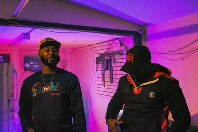 Man and woman standing against illuminated wall