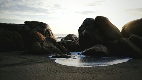 Rocks on beach against sky