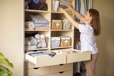 Midsection of woman using mobile phone while standing in store