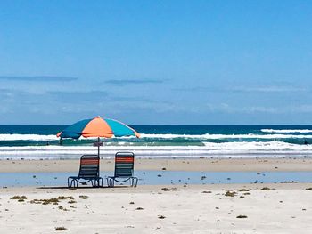 Lifeguard hut on beach against sky