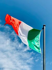 Low angle view of flag against blue sky