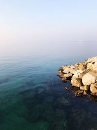 Scenic view of rocks in sea against sky