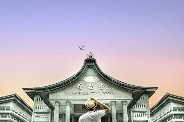 STATUE IN CITY AGAINST SKY