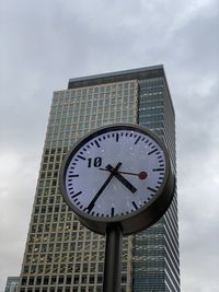 Low angle view of clock against sky