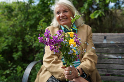 Portrait of happy woman holding flower bouquet