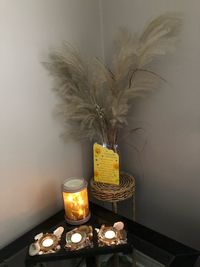 Flower vase on table against wall